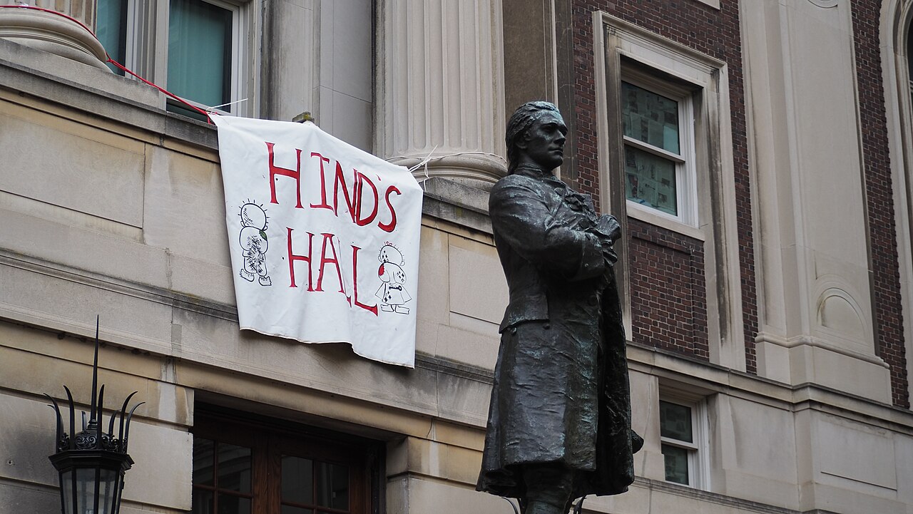 1280px-Hind's_Hall_banner_behind_Hamilton_statue.jpg